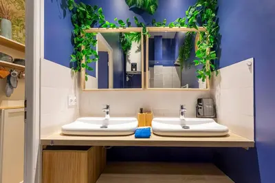 a bathroom with two sinks and a mirror at Boho Chic Apartment in Old Town in Nice