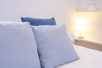 two white pillows sitting on a bed next to a lamp at #5 Eagle Nest 5mins walk of the Sea AC Wifi Old town in Nice