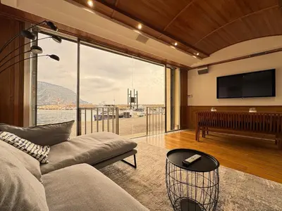 a living room with a couch and a flat screen tv at Seaside Serenity, Portside Apartment in Èze
