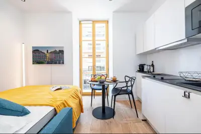 a bedroom with a bed and a table in a kitchen at Cozy studio near the sea in Nice