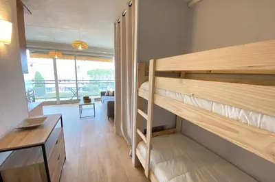 a room with bunk beds and a living room at Lovely 4-person studio - pool and sea in Cros-de-Cagnes