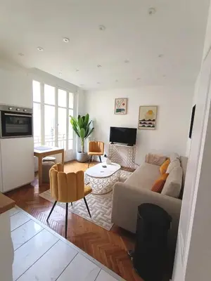 a living room with a couch and a table at Superbe appartement, aperçu mer, Negresco-centre in Nice