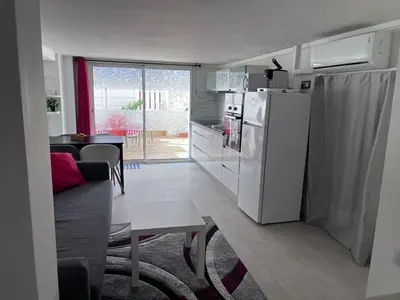 a kitchen and living room with a white refrigerator at duplex en bord de mer in Cagnes-sur-Mer
