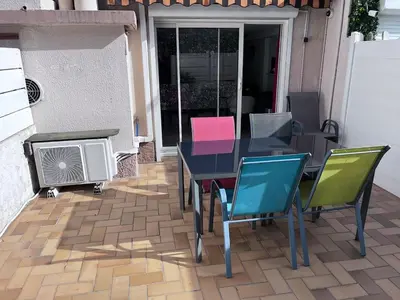 a patio with a table and chairs and a heater at duplex en bord de mer in Cagnes-sur-Mer