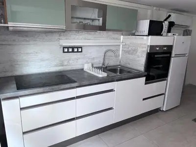 a white kitchen with a sink and a microwave at duplex en bord de mer in Cagnes-sur-Mer