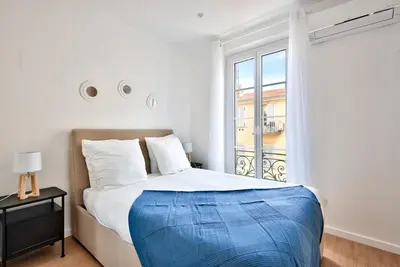 a white bedroom with a bed and a window at Appartement Cosy centre Nice in Nice