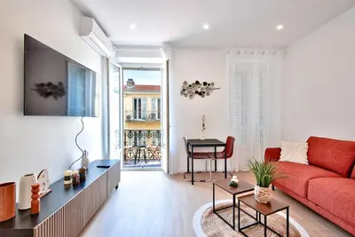 a living room with a red couch and a table at Appartement Cosy centre Nice in Nice