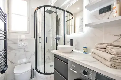 a white bathroom with a shower and a sink at Appartement Cosy centre Nice in Nice