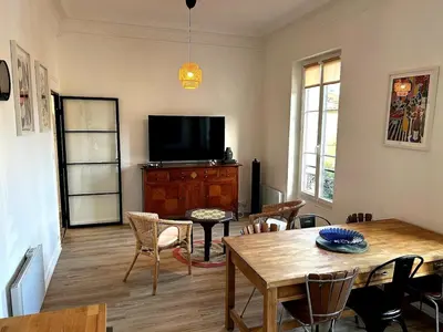 a room with a bed and a table and a window at Charming Flat in Nice Villa in Nice