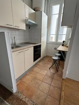 a kitchen with white cabinets and a tile floor at Liberation Cozy Studio in Nice in Nice
