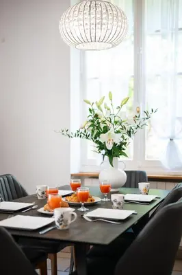 a dining room table with a vase of flowers at Villa Mi Rancho Vue mer - Jardin - Plage et resto à 5 min in Villefranche-sur-Mer