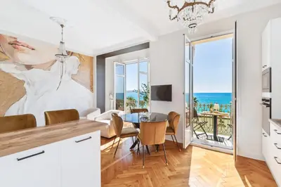a kitchen and dining room with a view of the ocean at Happyfew La Suite Del Sol in Nice