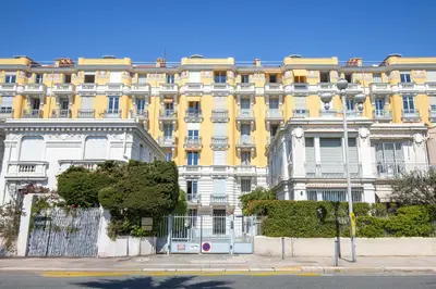 a large yellow and white building on a street at Happyfew La Suite Del Sol in Nice