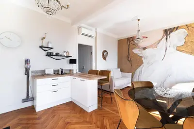 a kitchen and dining room with a table and a drawing on the wall at Happyfew La Suite Del Sol in Nice