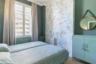a bedroom with a bed and a mirror and a window at Happyfew La Suite Del Sol in Nice