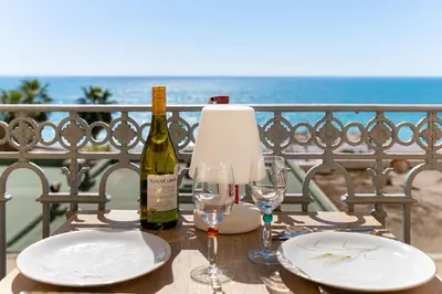a table with two glasses and a bottle of wine at Happyfew La Suite Del Sol in Nice