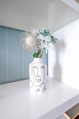 a white vase with flowers sitting on a counter at Panoramic Sea View - Promenade des Anglais in Nice