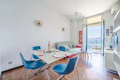 a dining room with a table and blue chairs at Panoramic Sea View - Promenade des Anglais in Nice
