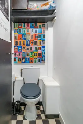 a bathroom with a toilet with a painting on the wall at Panoramic Sea View - Promenade des Anglais in Nice