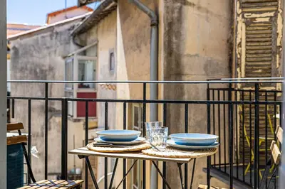 a table with plates and glasses on a balcony at Appartement neuf 2 pièces Port in Nice