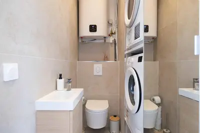 a bathroom with a sink and a washing machine at Appartement neuf 2 pièces Port in Nice