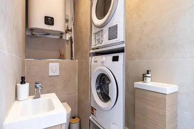 a bathroom with a washing machine and a sink at Appartement neuf 2 pièces Port in Nice