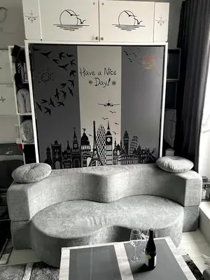 a living room with a couch and a wall with a mural at Petit Bijou niçois in Nice