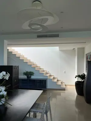 a staircase in a room with a table and chairs at La perle - villa de luxe in Villefranche-sur-Mer