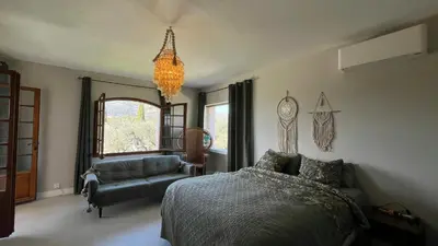 a bedroom with a bed and a couch and a chandelier at Provencal Villa With Pool And Panoramic Views in La Gaude