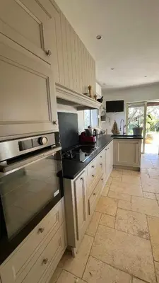 a kitchen with white cabinets and black counter tops at Provencal Villa With Pool And Panoramic Views in La Gaude