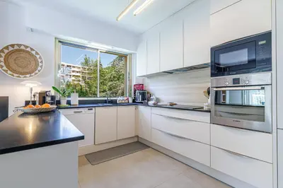 a kitchen with white cabinets and a large window at MY CASA - GAIRAUT - 5 rooms - Terrasse in Nice