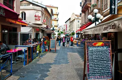 a street with tables and chairs and people walking down the street at Sea Side, Modern, Nice Promenade in Nice