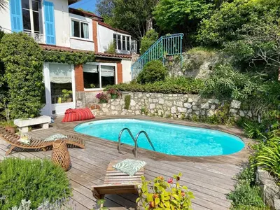 a swimming pool in front of a house at Nice Signature Baracca in Nice