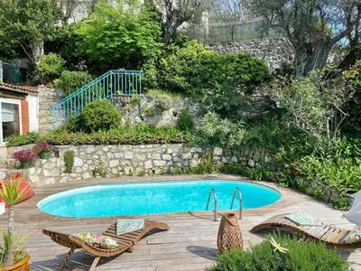 a swimming pool in a yard with two chairs and a table at Nice Signature Baracca in Nice