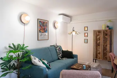 a living room with a blue couch and a table at #46 Terrace AC 4mins walk Sea Tram T2 Airport Port in Nice