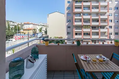 a table and chairs on a balcony with a view of a building at #46 Terrace AC 4mins walk Sea Tram T2 Airport Port in Nice
