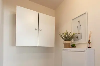 a kitchen with white cabinets and a plant on a refrigerator at #46 Terrace AC 4mins walk Sea Tram T2 Airport Port in Nice