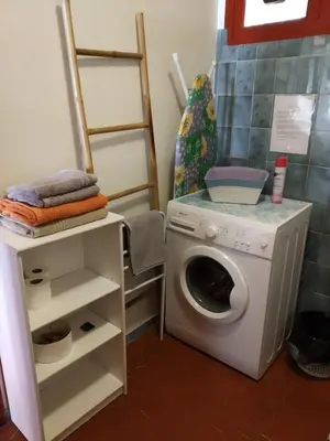 a laundry room with a washing machine and a shelf at Appartement à deux pas de la plage in Nice