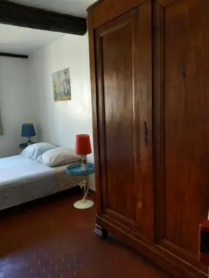 a bedroom with a bed and a wooden closet at Appartement à deux pas de la plage in Nice