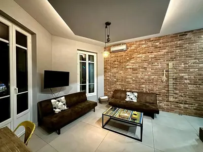 a living room with a couch and a brick wall at Splendide Nice Centre Clim in Nice