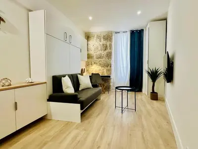 a living room with a black couch and a table at AA G Cocon Lamartine - City center in Nice