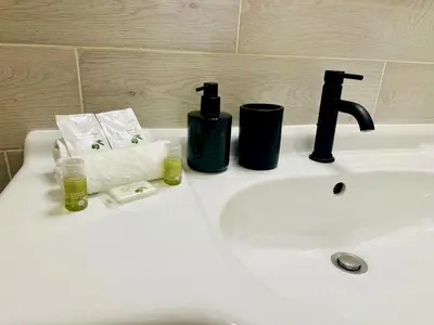a bathroom sink with a faucet and two cups on it at AA G Cocon Lamartine - City center in Nice