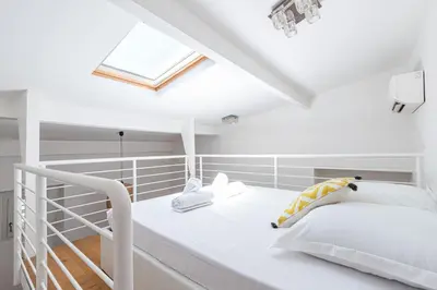 a white bed in a room with a skylight at 33 GAMBETTA - Appartement 2 pieces Mezzanine in Nice