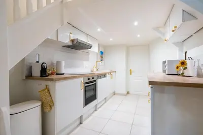a kitchen with white appliances and a staircase at Cozy Apartment in Old Town Nice in Nice