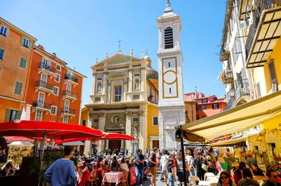 a crowd of people walking down a street with a clock tower at Cozy Apartment in Old Town Nice in Nice
