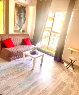 a living room with a couch and a table at Fully-equipped 2-bedroom apartment in Nice