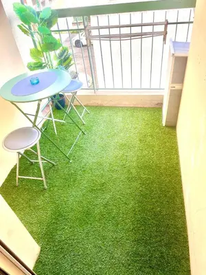 a balcony with green flooring in a room with a table and chairs at Fully-equipped 2-bedroom apartment in Nice