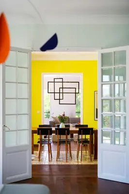 a dining room with yellow walls and a table and chairs at Sea View Villa In The Hills Of Nice in Nice
