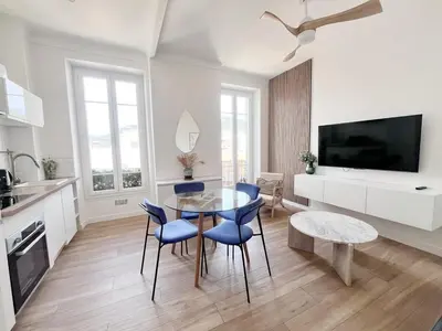 a kitchen and dining room with a glass table and blue chairs at RF113 - 3P Appartement Cosy et Lumineux in Nice