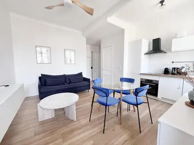 a kitchen and living room with a table and blue chairs at RF113 - 3P Appartement Cosy et Lumineux in Nice